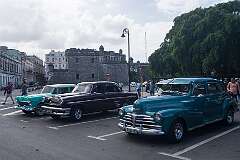 A Chevrolet of 1955, a Mercury of 1954 and a Chevrolet of 1948  in front of the 16th-century Castillo de la Real Fuerza, Havana, Cuba.