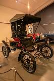 A 1903 Oldsmobile "Curved Dash" Runabout, the first mass-produced automobile, built on an assembly line;  about 19,000 were built,