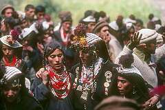 Bumburet, Pakistan, 1979 - Kalash women, wearing headgear with kauri shells, and a man dancing at a “Krakal” funeral ceremony.