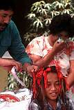 Alofi, Niue, 1985 - The pastor cutting a lock of a boy's hair, for the first time, in a traditional Polynesian hair cutting ceremony.
