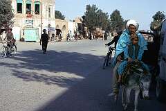 A father and his young son on a donkey in the main street of Herat.