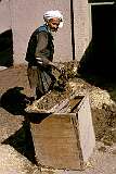 An old man mixes mud and straw in a back alley in Herat. This will be used to repair walls of the adobe or mud-brick houses here.