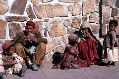 A family of one of Afghanistan's nomadic peoples waiting on the street for their husband and father to return from business.