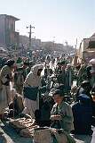 A street market in the bazaar of Kandahar. Large round slabs of “nan”, Afghan bread, are for sale in the foreground. In this strict Muslim society, the market is an all-male affair.