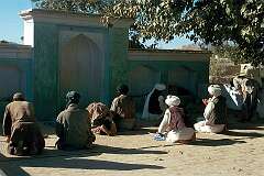 Afternoon prayers near a shrine in the village of Del Khatay on the outskirts of Kandahar.