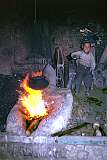 In a smith's workshop in a back street of Mazar a boy helps by operating a fan driven by a wheel. Children often have to work at an early age.
