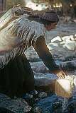 Tundu Angmo, wearing a sheepskin cloak, fetching water.