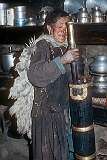 Nurdzin Dolma making buttered tea in a churn, at home.