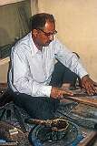 The father of the artist using a file smoothing the piece that was made using Khātam, an ancient Persian technique of inlaying, a version of marquetry.