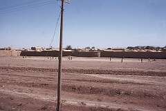 A village along the road, boys playing football.