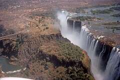 The Victoria Falls on the border of Zimbabwe and Zambia, with the 1905 Victoria Falls Bridge over the gorge, seen from the Zambian side.
