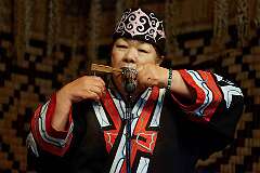 Shiraoi, Hokkaido, Japan, 2014 - Playing the “mukkuri”, a bamboo jaw harp, by an Ainu woman in Porotokotan Ainu Museum.