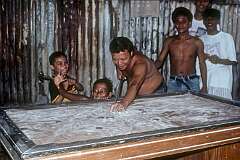 Manila, Luzon, Philippines, 1990 - Playing pool using disks on a table with talcum powder, in Tondo.