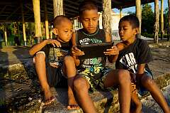 Salua, Manono, Samoa, 2013 - Playing a game on an iPad.