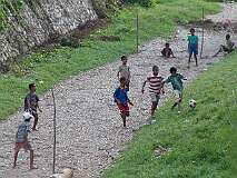 Dili, Timor Leste, 2004 - Playing a game of football in a dry drainage canal.