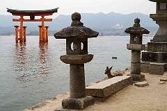 Miyajima, Honshu, Japan - The “floating” torii gate and stone lanterns on Itsukushima, an island in the Inland Sea of Japan.